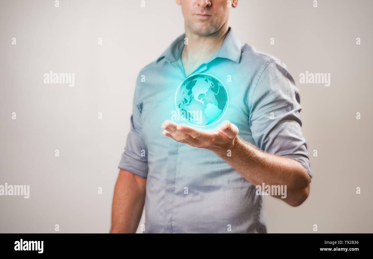 Casualy habillé businessman holding projections virtuelles du monde dans sa main Banque D'Images