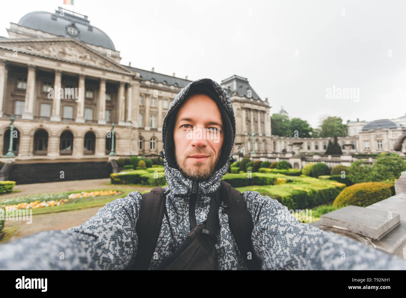 Le mec se dresse contre l'arrière-plan du Palais Royal de Bruxelles et prend des photos mémorables sur son appareil photo, Belgique Banque D'Images