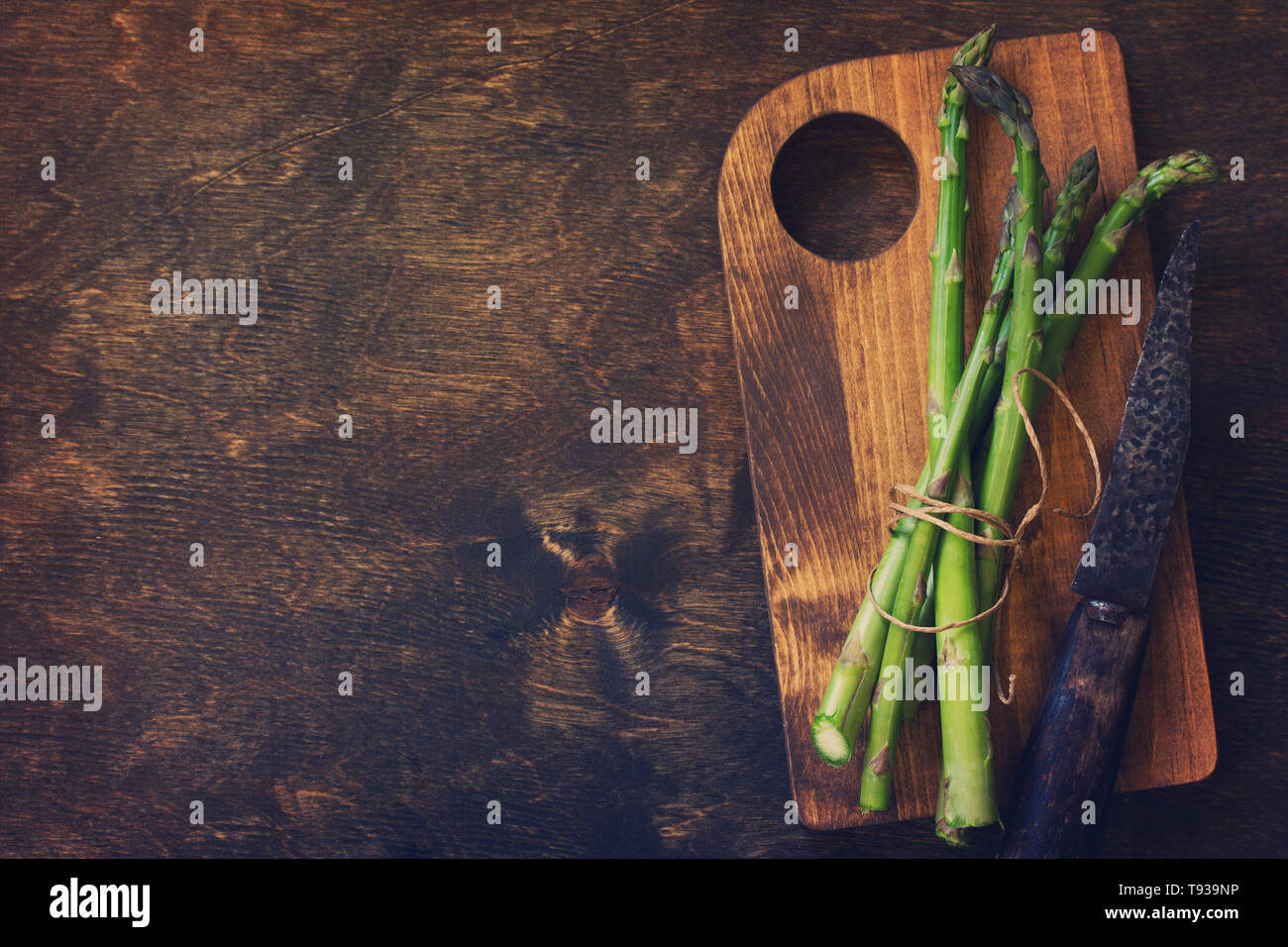Bande d'asperges vertes fraîches sur fond de bois. Vue supérieure de la télévision. Espace libre pour votre texte. La tonalité de l'image. Banque D'Images