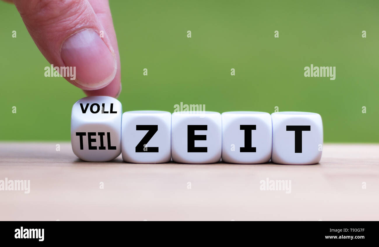 La main est le tournant d'un dés et change le mot allemand 'Vollzeit' ('full-time' en anglais) à 'Teilzeit' ('à temps" en anglais) ou vice versa. Banque D'Images