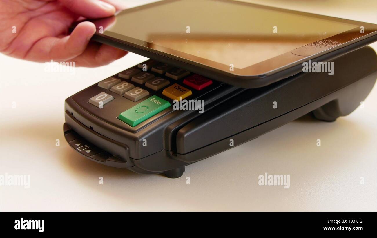 Payer avec une tablette sans fil sur la borne de carte de crédit. Banque D'Images