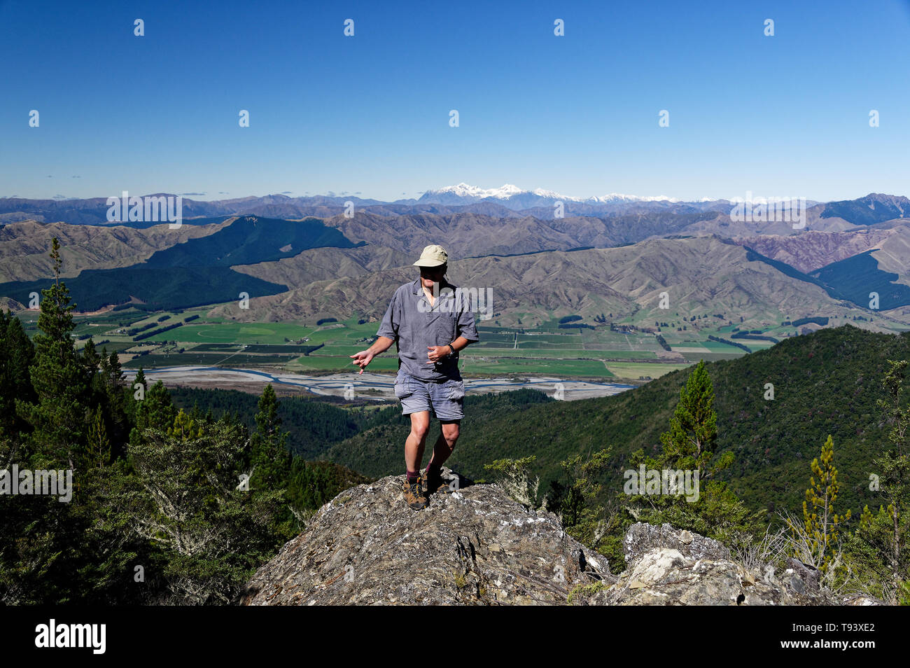 Dansez comme personne ne regarde, sur un éperon rocheux en Nouvelle-Zélande, un homme plus âgé apprécie le grand air et se comporte plus jeune que ses années. Banque D'Images