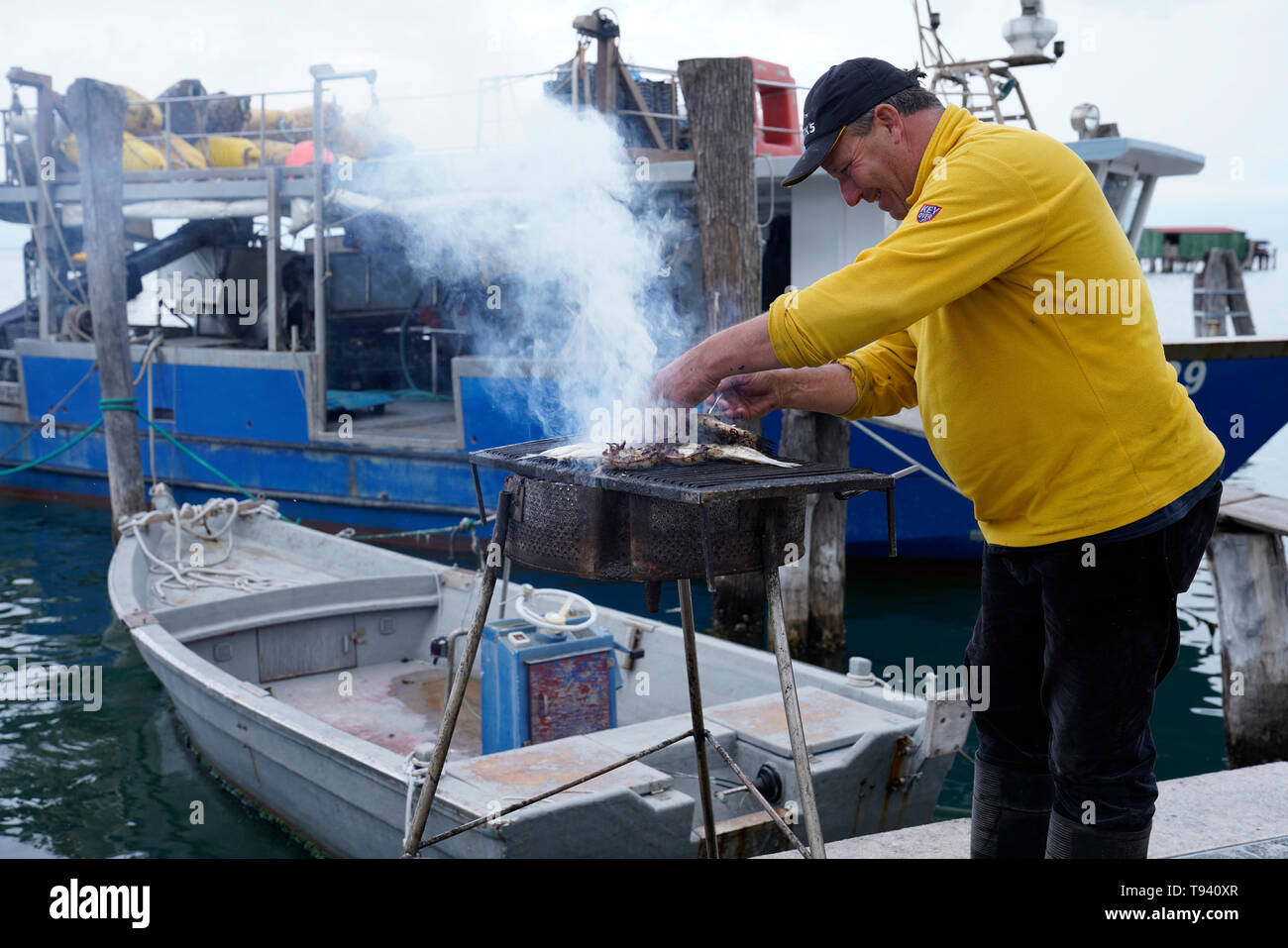 Griller son poisson pêcheur,Pelestrina, Italie Banque D'Images