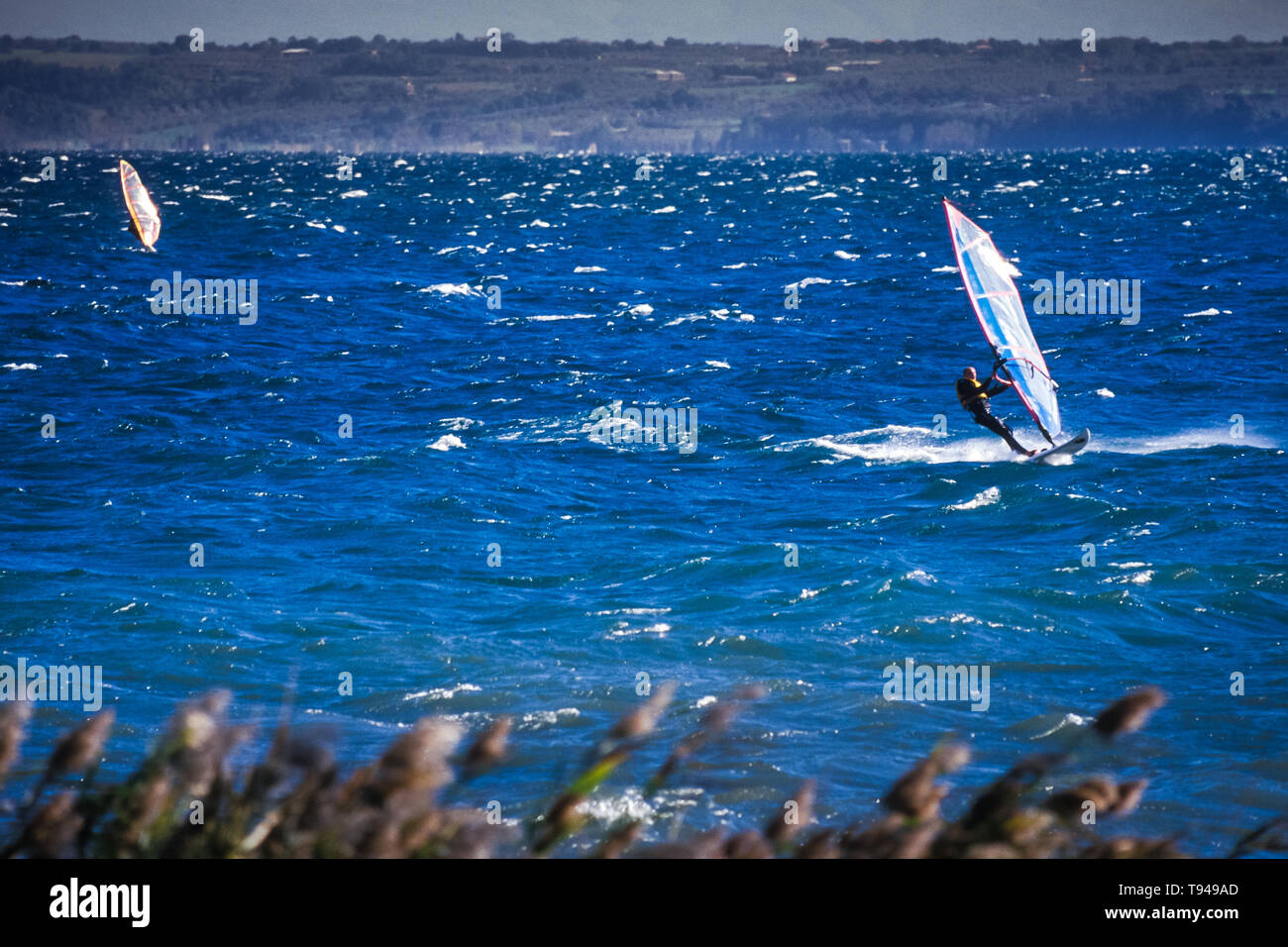 Surfers sur le lac de Bolsena (Italie) - La ville médiévale avec un château sur le lac de Bolsena, la région Latium, en Italie centrale Banque D'Images