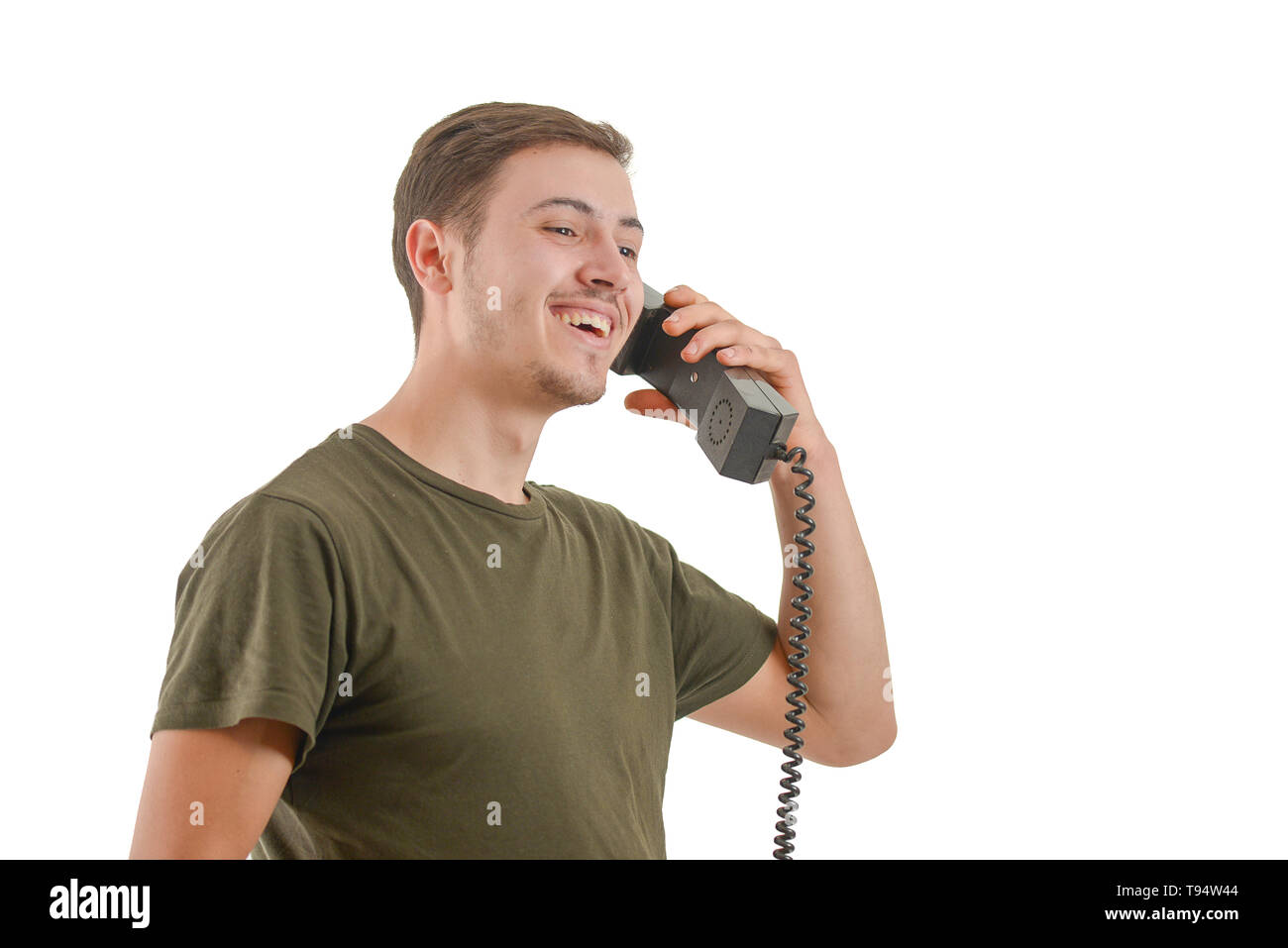 Photo d'un homme qui parle à un ancien téléphone, isolé sur fond blanc Banque D'Images