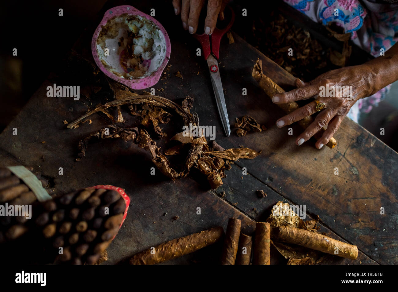 Mains de Laura Peña, un 67-ans femme salvadorienne, sont considérés tout en roulant les feuilles de tabac, cigares faits à la main pour rendre à Suchitoto, El Salvador. Banque D'Images Mains de Laura Peña, un 67-ans femme salvadorienne, sont considérés tout en roulant les feuilles de tabac, cigares faits à la main pour rendre à Suchitoto, El Salvador. Banque D'Images