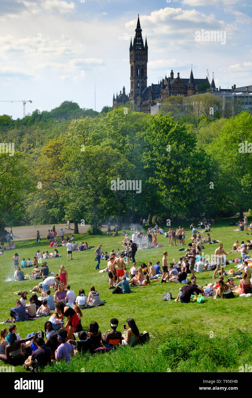 Temps chaud et personnes à Glasgow Kelvingrove Park avec l'Université de Glasgow à l'arrière à Glasgow West End, Ecosse, Royaume-Uni Banque D'Images