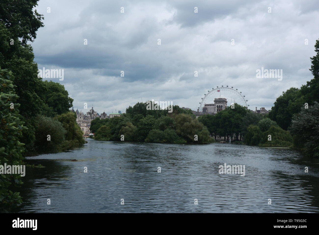 Le Les jardins de Buckingham Palace, Londres avec le London Eye et autres bâtiments au loin. En outre, il y a un lac dans l'avant-plan et d'arbres. Banque D'Images