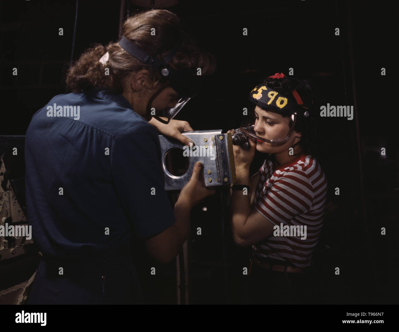 Deux femmes employés de North American Aviation, Incorporated, l'assemblage d'une section d'aile pour un avion de chasse P-51. Bien que l'image de l' 'Rosie Riveter reflète le travail industriel de soudeurs et riveter, la majorité des femmes qui travaillent en usine non rempli des postes dans tous les secteurs de l'économie. Ce qui unifiait les expériences de ces femmes était qu'elles étaient elles-mêmes, et le pays, qu'ils pourraient faire un travail d'homme et pourrait bien le faire. Photographié par Alfred T. Palmer, 1942. Banque D'Images