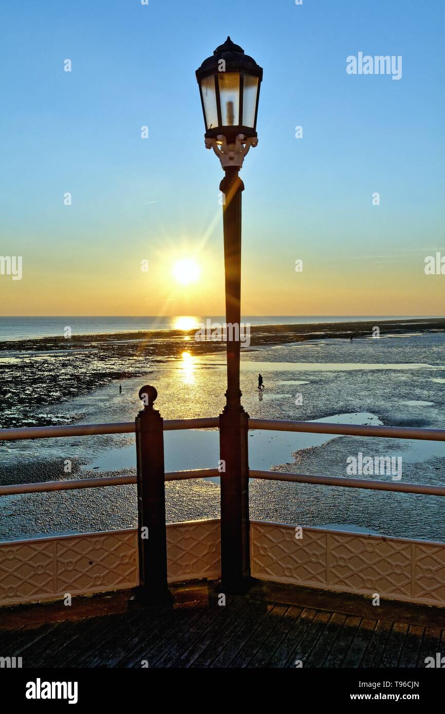 Lampadaire décoratif jetée de Worthing avec un hiver spectaculaire coucher de soleil sur la mer West Sussex England UK Banque D'Images
