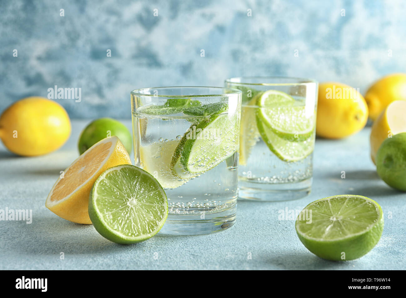 Verres d'eau avec du citron et lime sur table couleurs Banque D'Images