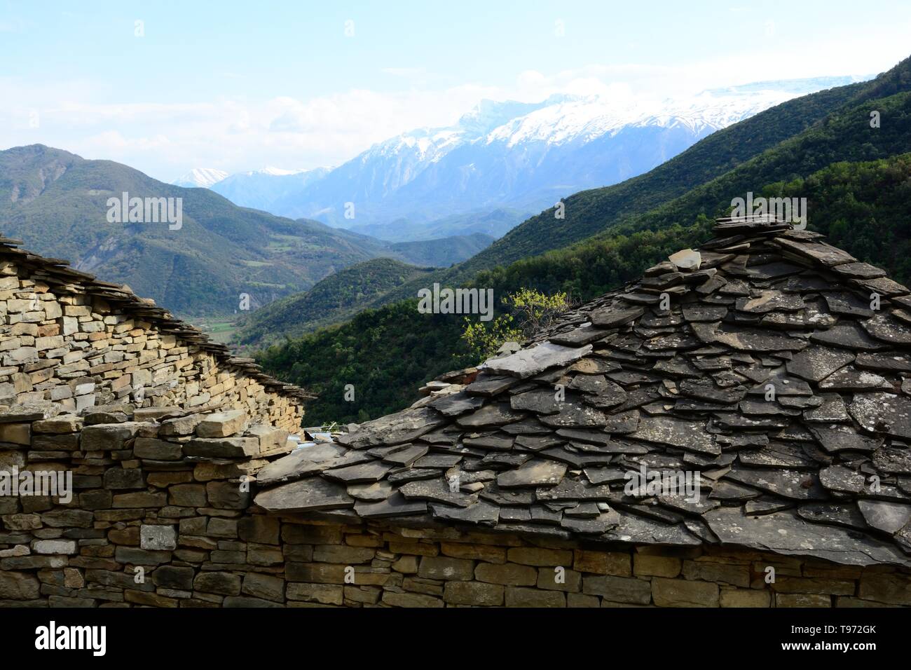 À la plus vieille toiture ardoise toits d'une maison de village albanais rurales vers les montagnes enneigés des Nemmerck l'Albanie Banque D'Images
