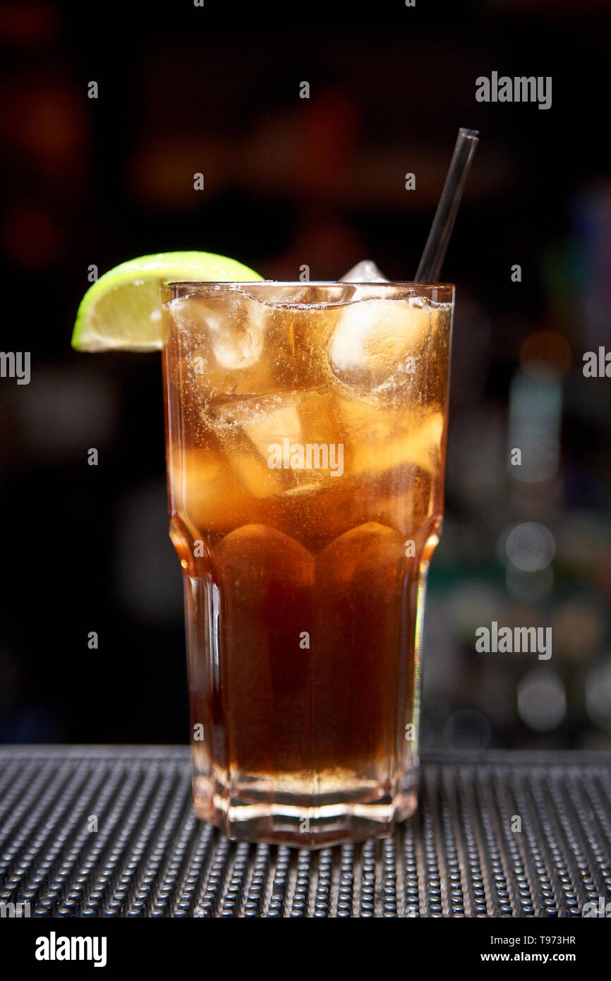 Cocktail froid sombre sur un arrière-plan flou avec bokeh. Banque D'Images