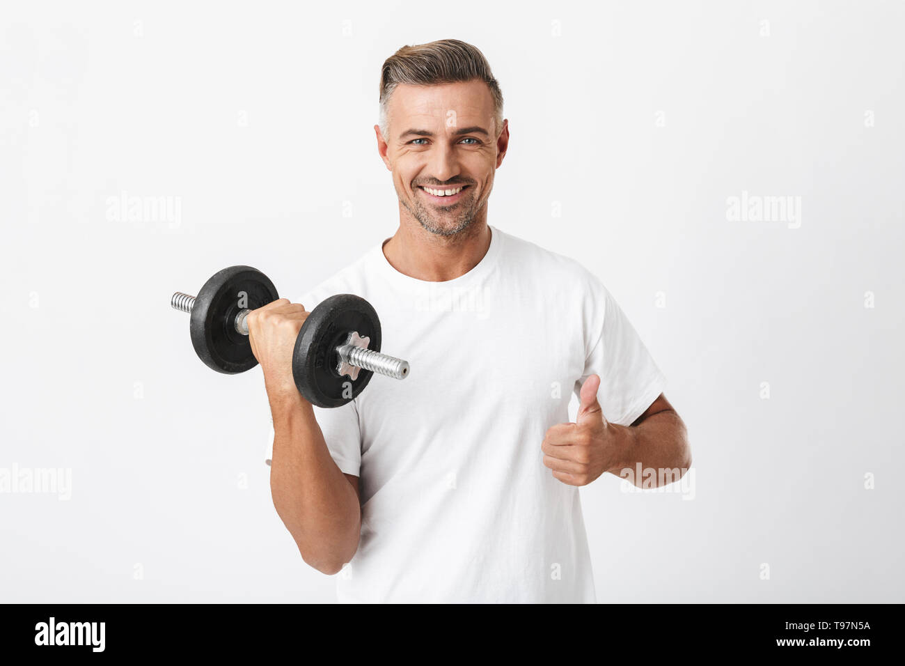 Image de sportsman 30s avec port de soie t-shirt biceps de pompage et de levage isolés haltère over white background Banque D'Images