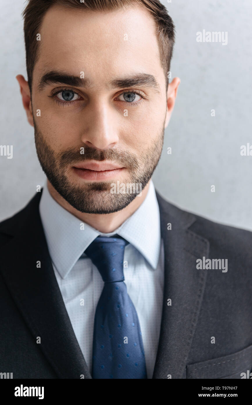 Cose d'un beau costume homme portant sur mur gris Banque D'Images
