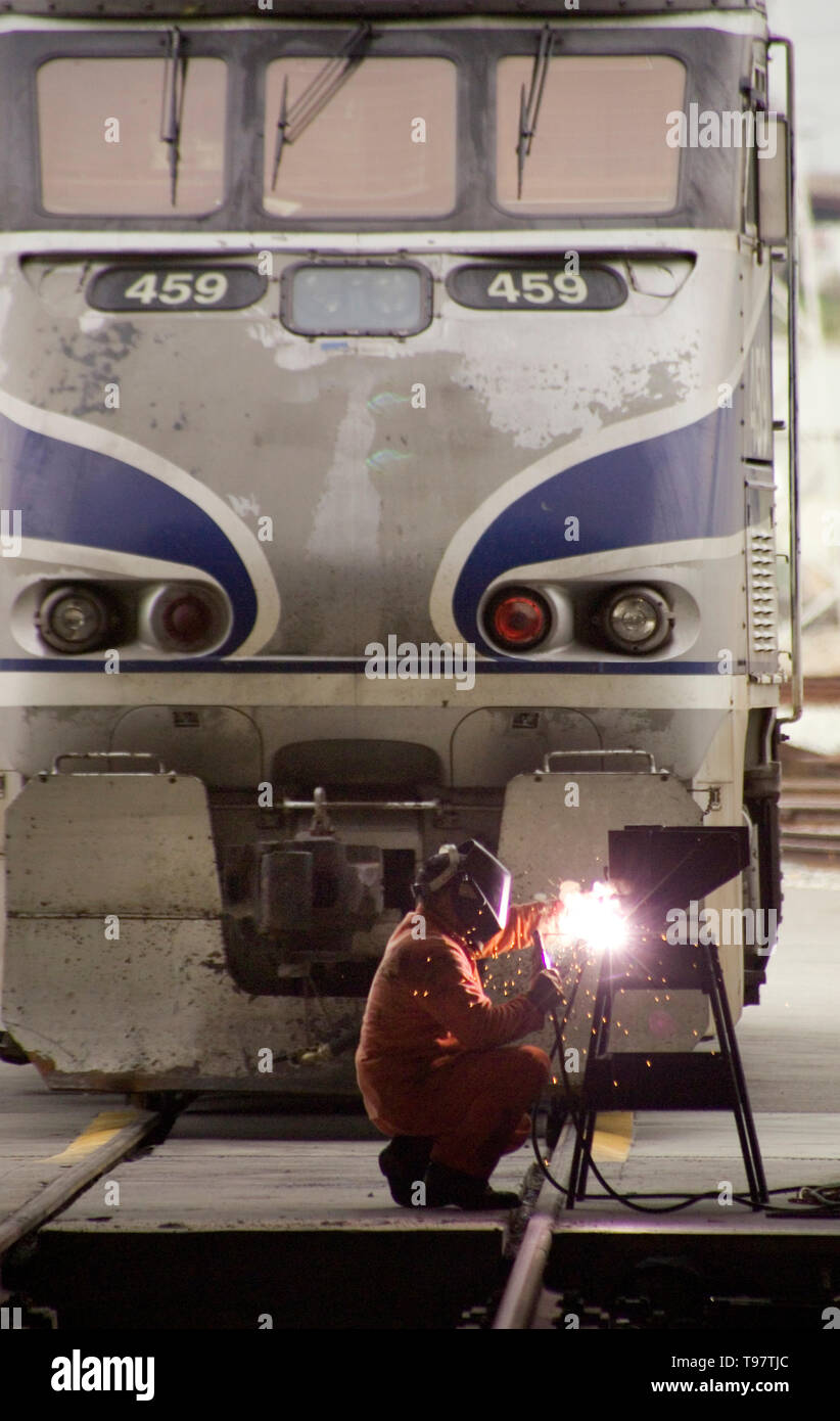 Encadré par une locomotive, un soudeur de triage effectue une réparation à Los Angeles. Banque D'Images