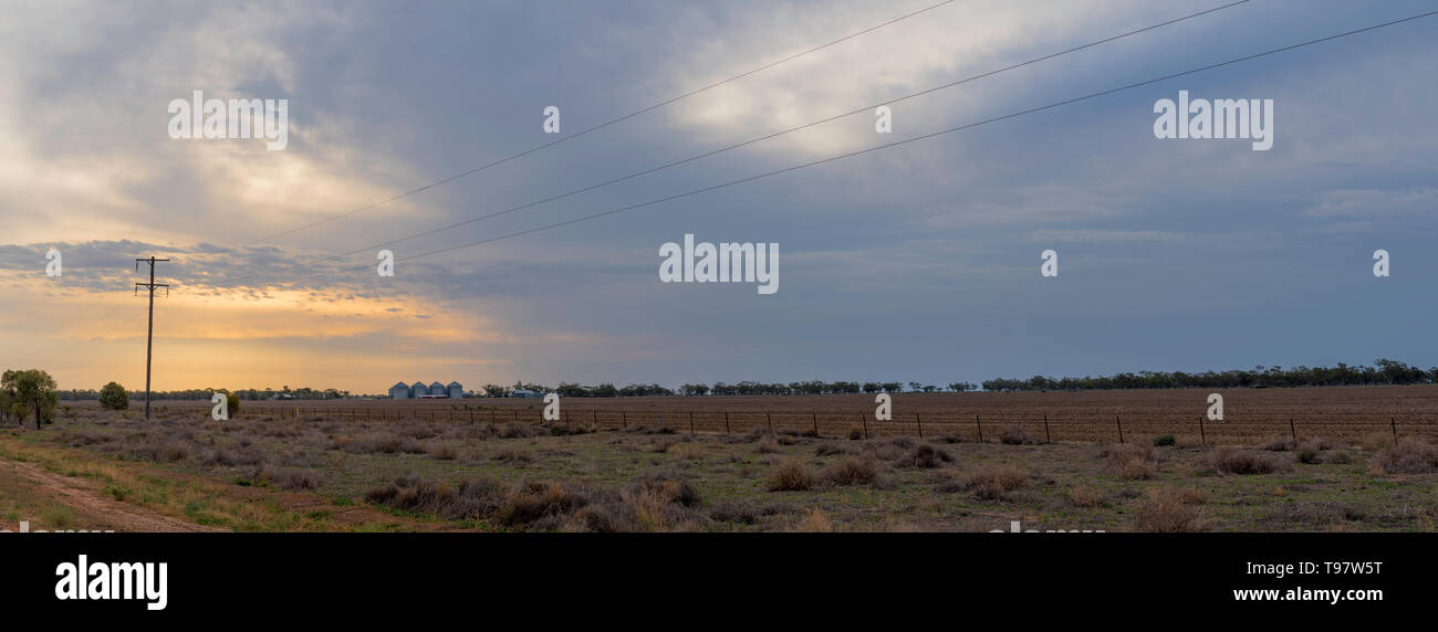 Mai 2019, Burren Junction, Australie : le coucher du soleil et nuages de pluie sur une grande télévision paddock labouré sur une exploitation touchée par la sécheresse dans l'ouest EN IN Banque D'Images