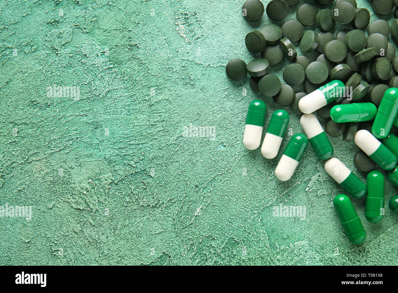 La spiruline en comprimés et gélules sur un fond de couleur Banque D'Images