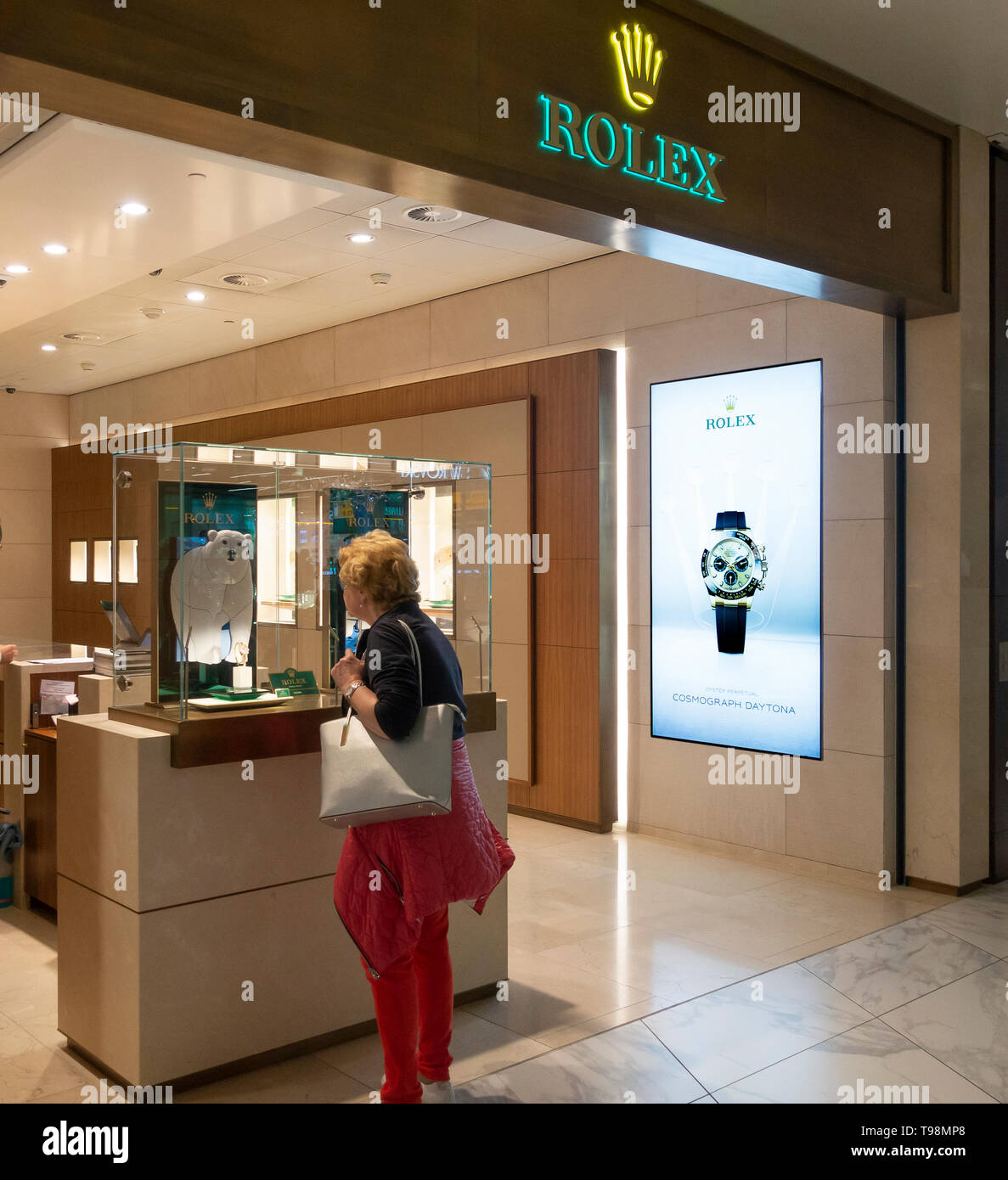 Une passagère se penche sur une montre dans une exposition à la Rolex de  vente au détail en l'aéroport de Schiphol, Amsterdam, Pays-Bas Photo Stock  - Alamy