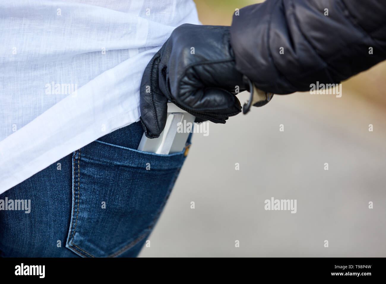 Voleur vole à la tire d'un téléphone mobile de poche du pantalon Banque D'Images