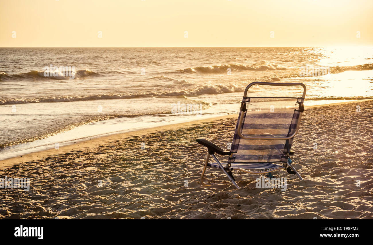 Bar d'aluminium chaise longue sur la plage de sable de l'océan au coucher du soleil la lumière et vintage tone Banque D'Images