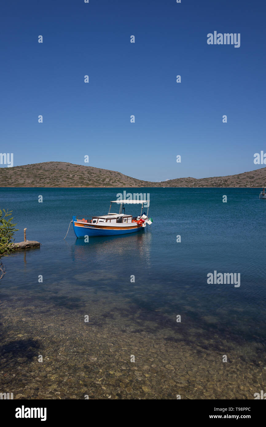 Bateau de pêche grec amarré à l'ancre dans la baie de Mirabello Elounda en Crète au bleu du ciel et mer Banque D'Images