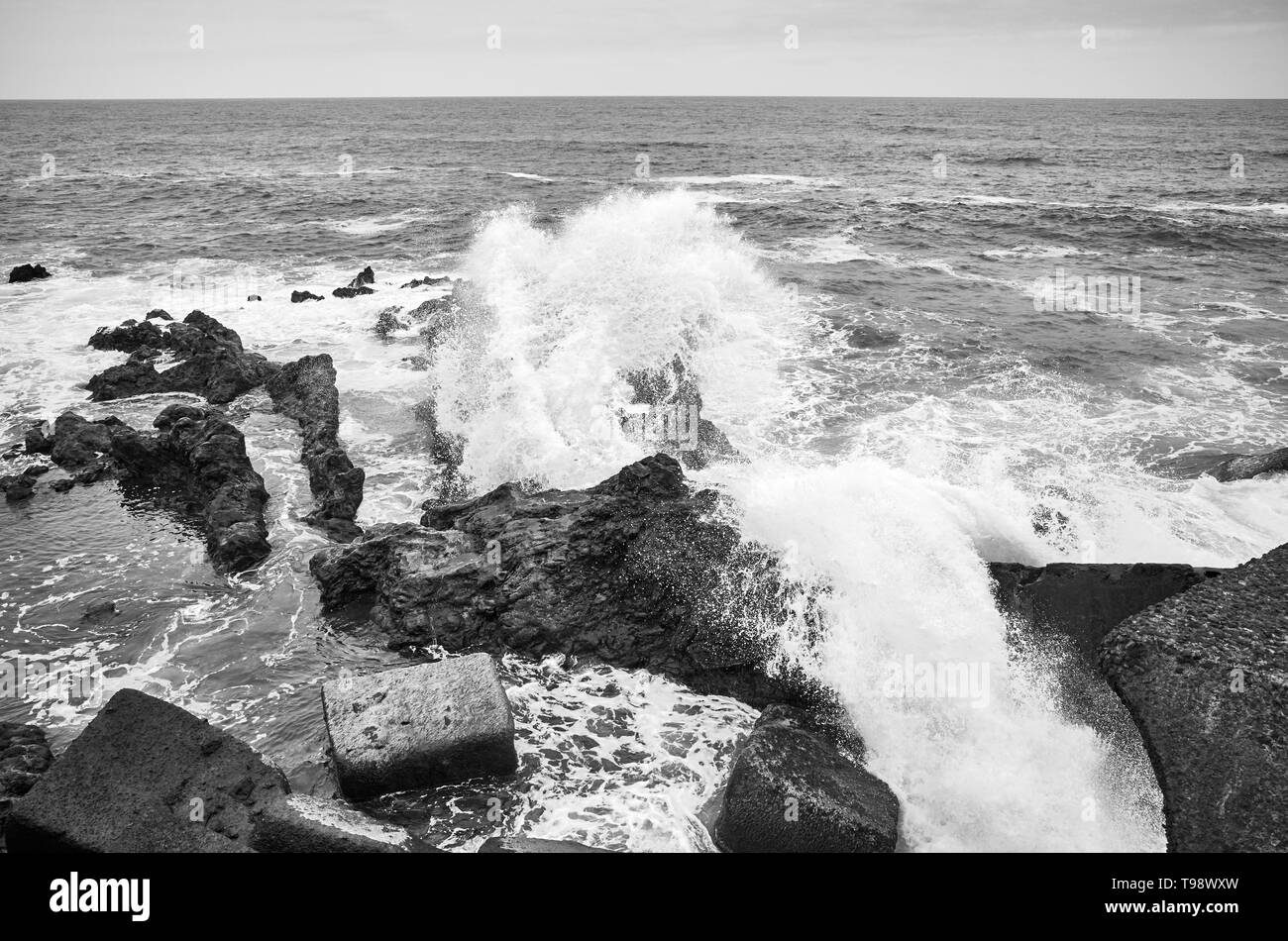 Photo noir et blanc de vagues se brisant sur les rochers, Tenerife, Espagne. Banque D'Images