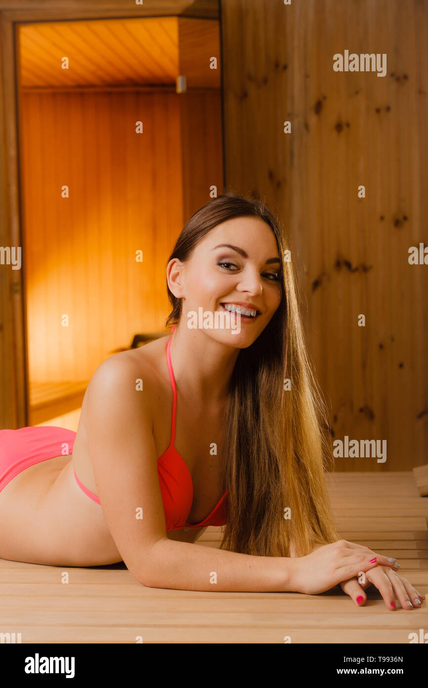 Heureux femme joyeuse de vous détendre dans un sauna finlandais en bois.  Jolie jeune fille en bikini au repos. Bien-être Spa plaisir Photo Stock -  Alamy