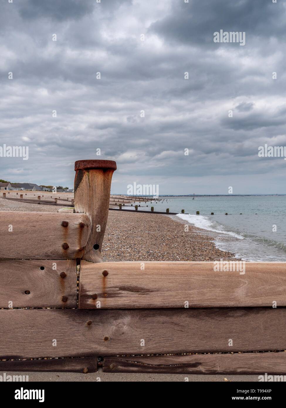 En bois patiné et usé d'un épi sur une plage de galets dans le sud de l'Angleterre Banque D'Images