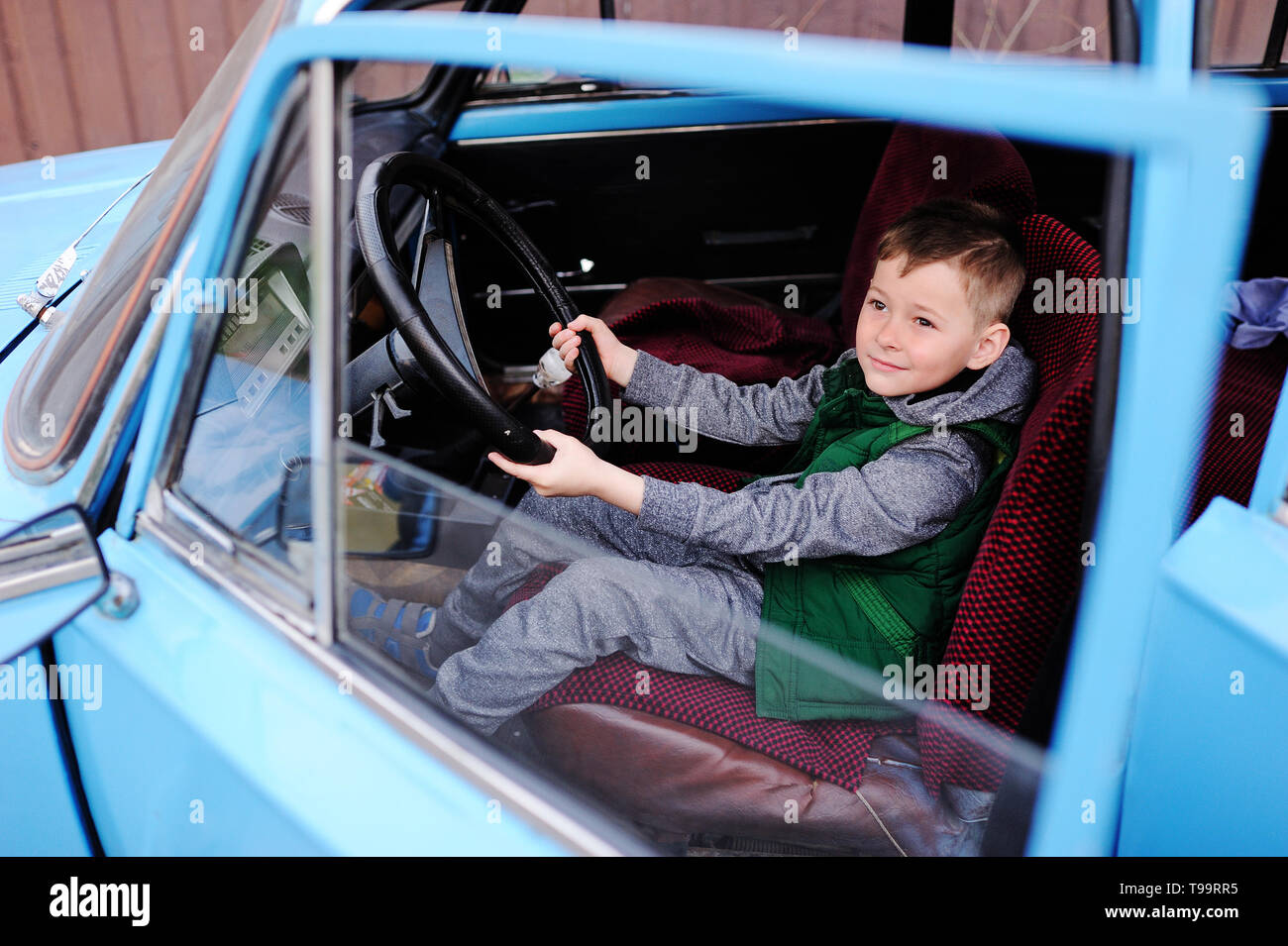 Bebe Garcon Assis Derriere Le Volant D Une Voiture Retro Bleu Photo Stock Alamy