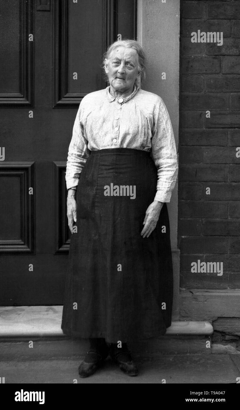 Une charmante demeure de caractère étude photographie d'une femme âgée qui pose sur une porte c1920 Photo de Tony Henshaw Banque D'Images