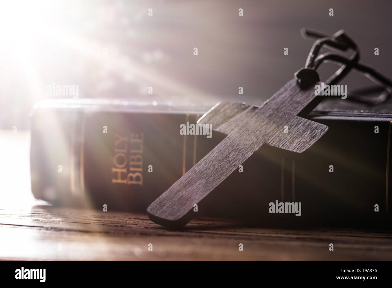 Croix chrétienne en bois sur la Sainte Bible sur table en bois Banque D'Images