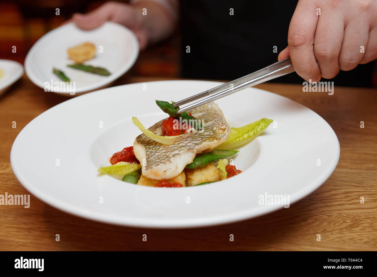 Chef, c'est la décoration d'un plat de poisson aux asperges Photo Stock -  Alamy