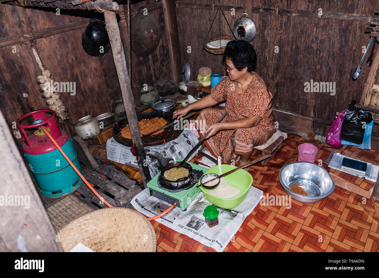 Une femme de Malaisie la cuisson des crêpes traditionnelles dans l'Iban maison ethnique. Sarawak Banque D'Images