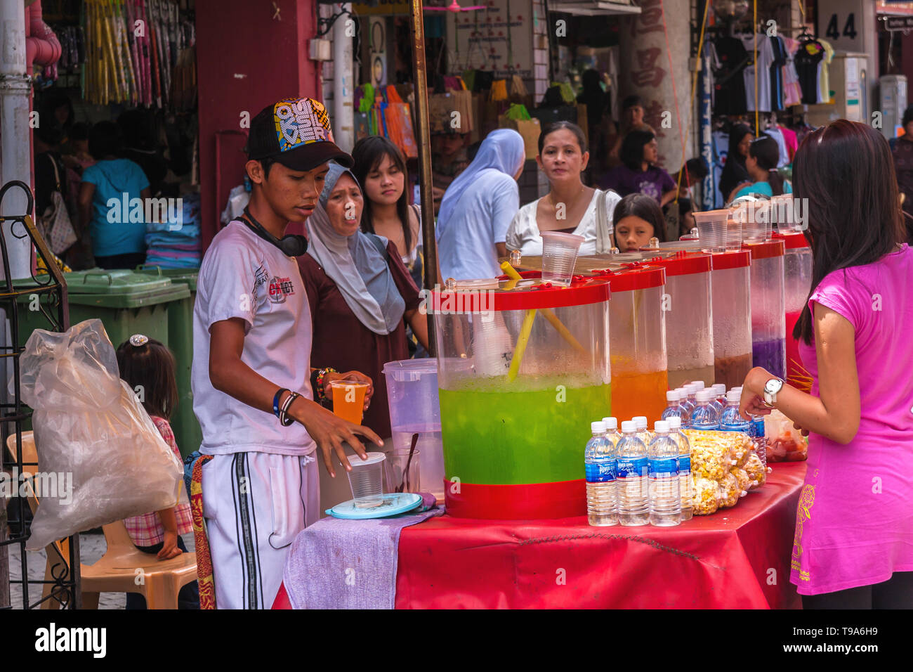 Un garçon de vendre du jus fraîchement pressé sur le marché à Kuching, Malaisie Banque D'Images