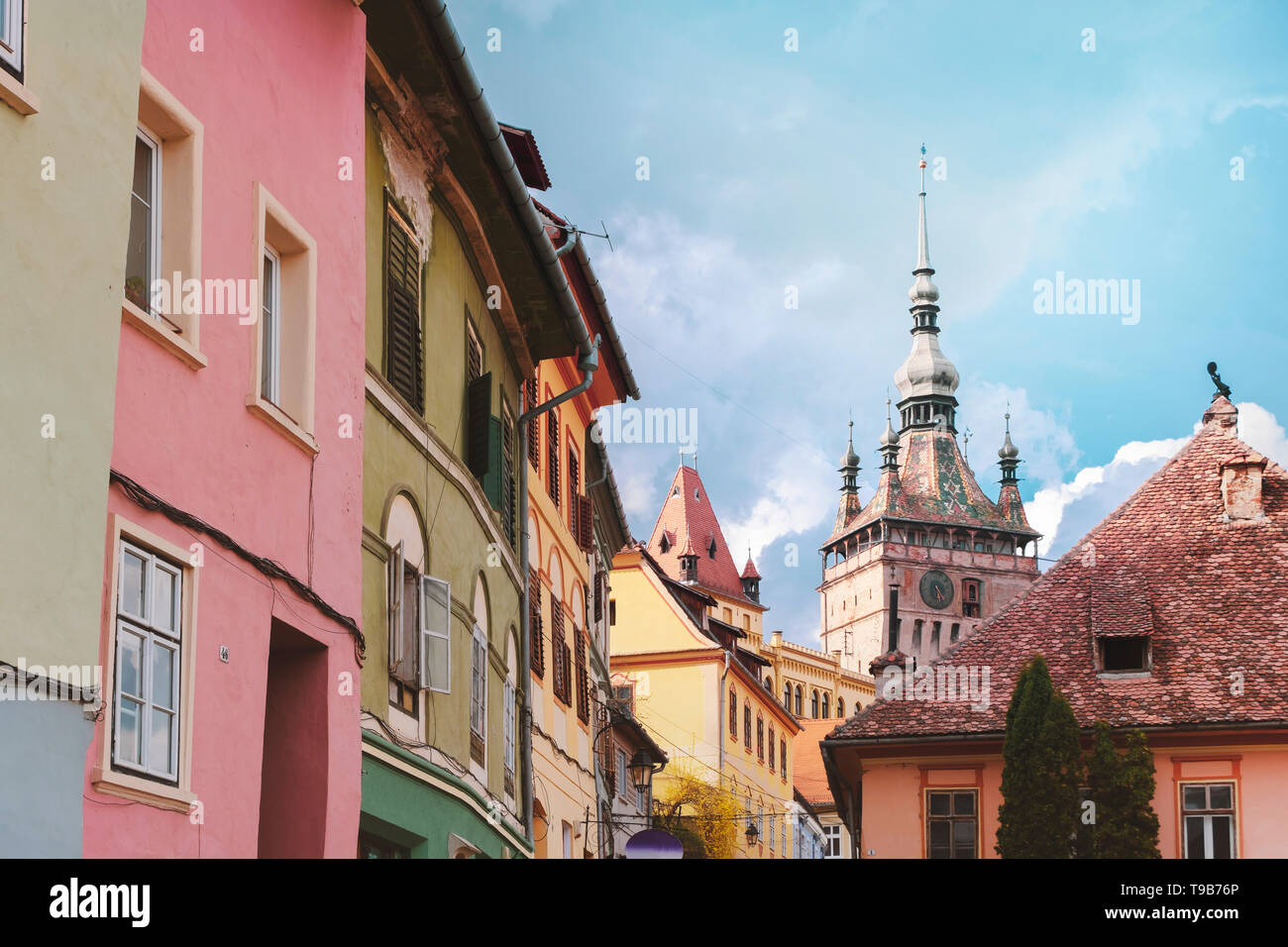 Vue vers le centre de la citadelle de Sighisoara avec la tour de l'horloge et maisons colorées sur une journée ensoleillée. Banque D'Images