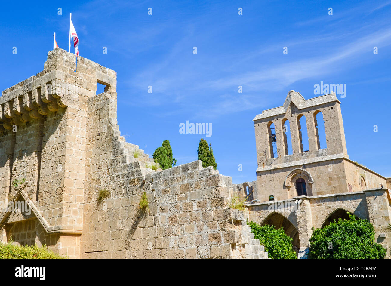 Ruines des murs historiques de l'abbaye de Bellapais médiévale dans la partie turque de Chypre. Capturé avec ciel bleu et vert des arbres autour. Banque D'Images