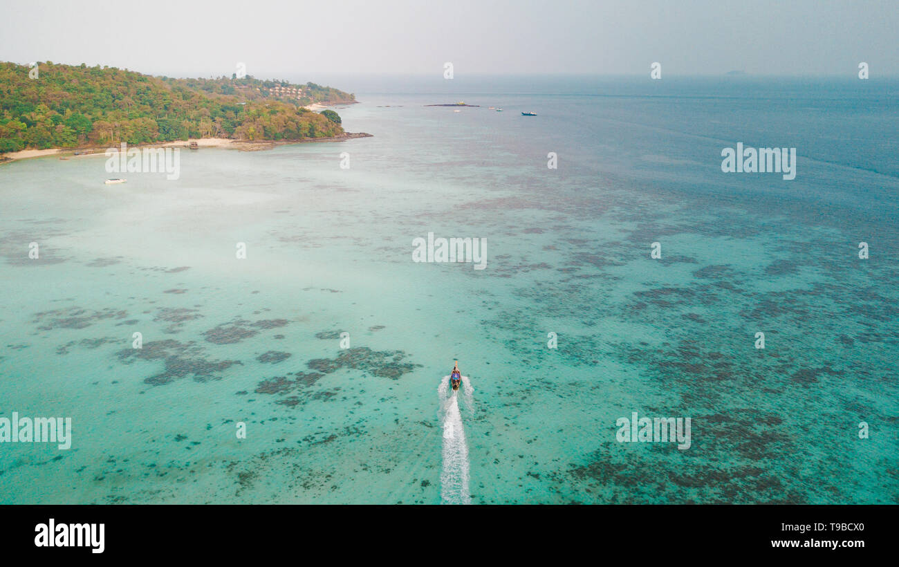 Les îles Phi Phi, THAÏLANDE : Drone voir de long tail boat crossing les eaux turquoise de la Thaïlande Mer. Banque D'Images