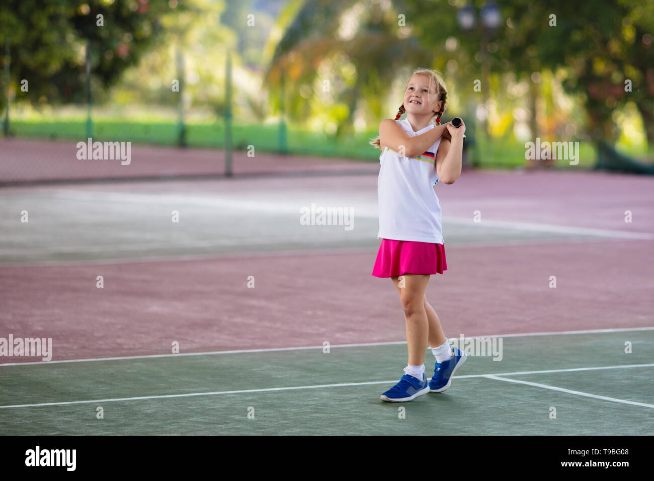 Enfant jouant au tennis sur un court intérieur. Petite fille avec raquette  de tennis et la balle dans le sport club. Exercice actif pour les enfants.  Activités d'été pour les enfants Photo