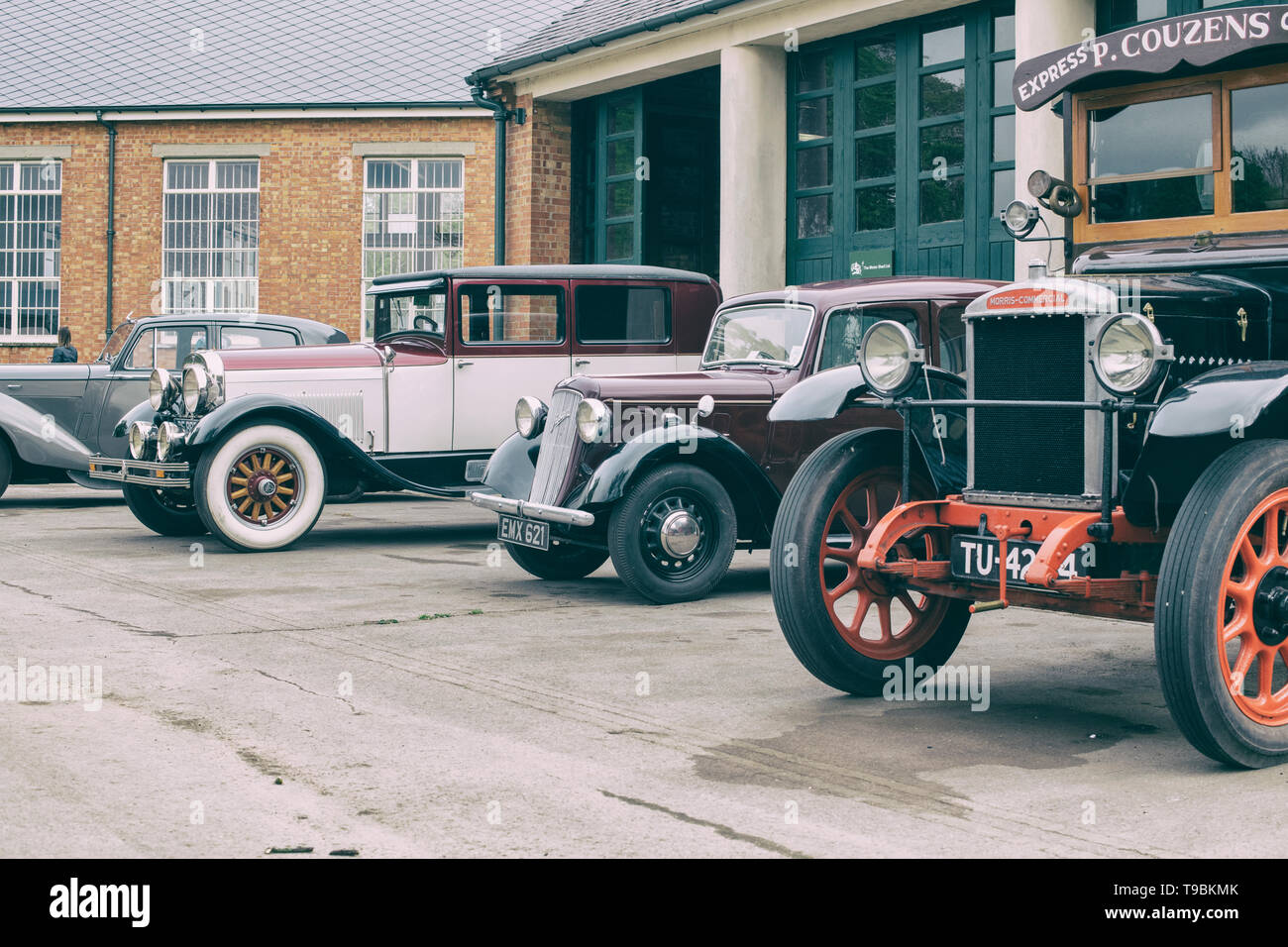 Voitures et camions Vintage à l'extérieur d'un garage à Bicester Heritage Centre 'Drive il Day'. Bicester, Oxfordshire, Angleterre. Vintage filtre appliqué Banque D'Images