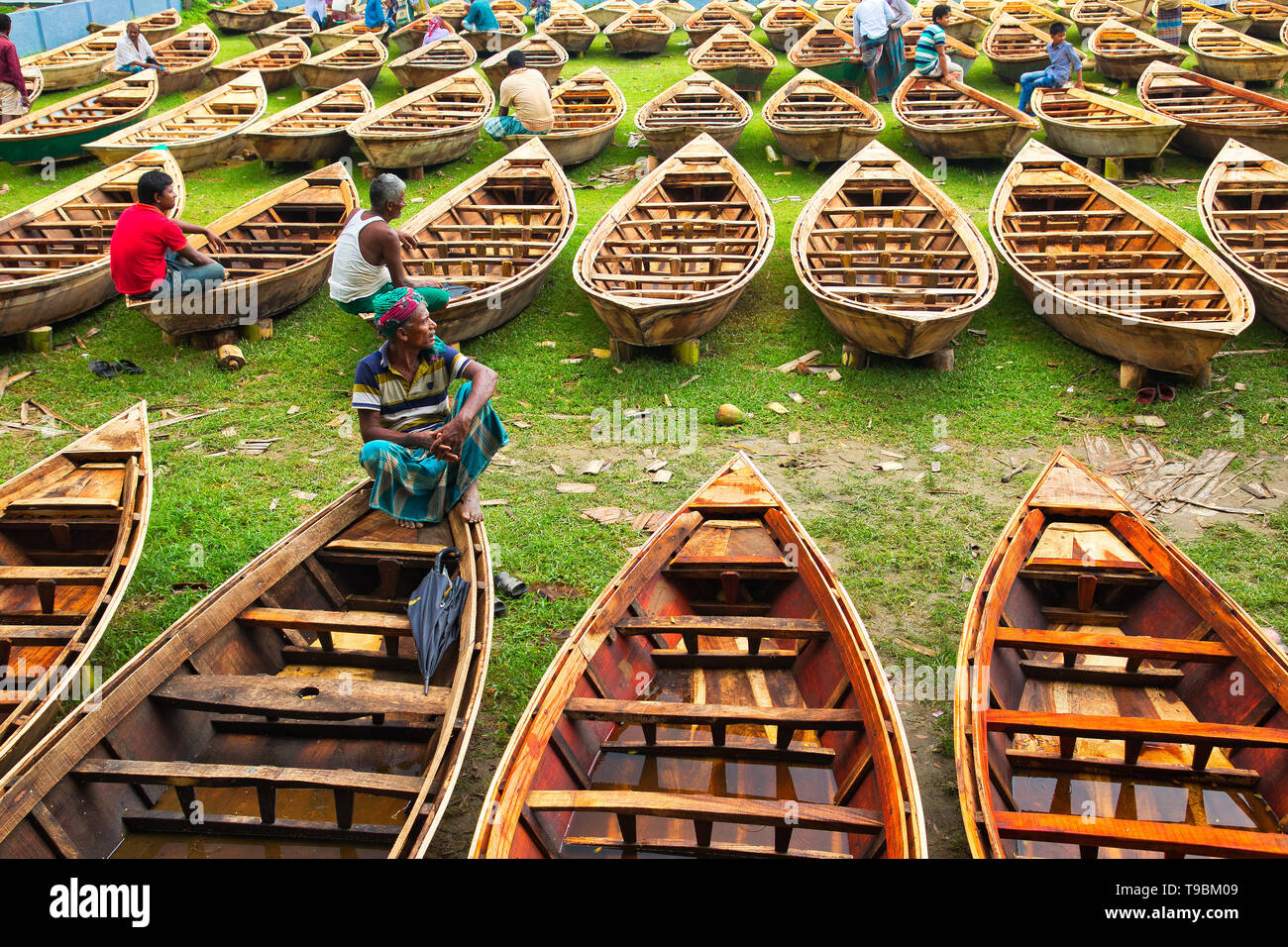 Des centaines de petits bateaux en bois vu affiché pour la vente à un marché que les sections locales à se préparer à la saison de la mousson. Des dizaines troupeau de loin pour acheter leur propre bateau à un marché en Manikganj, Bangladesh, de façon à être prête pour les inondations qui peuvent survenir à tout moment. Après de fortes pluies, il est courant que les berges des rivières pour éclater, submerger les villes et villages. Cela signifie que les voitures et les bus devenus superflus et les gens sont obligés de voyager par bateau. Chacun des bateaux en bois et avirons sont fait à la main par des artisans locaux et peut être acheté pour aussi peu que 1700 Taka bangladais - l'équivalent de 20 US dollar. Banque D'Images