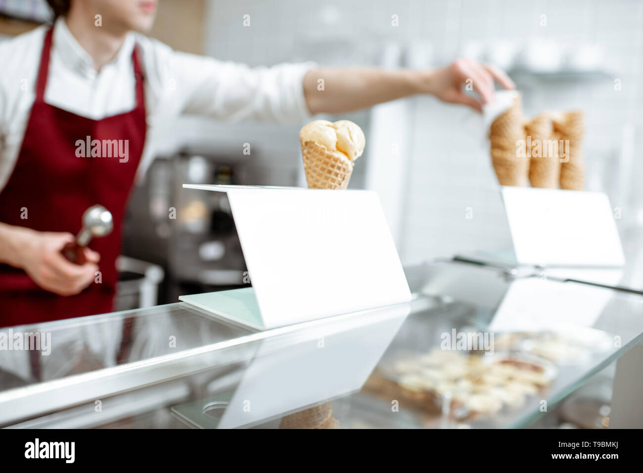 La crème glacée dans le cornet gaufré sur le comptoir de la pâtisserie avec le commercial sur l'arrière-plan Banque D'Images