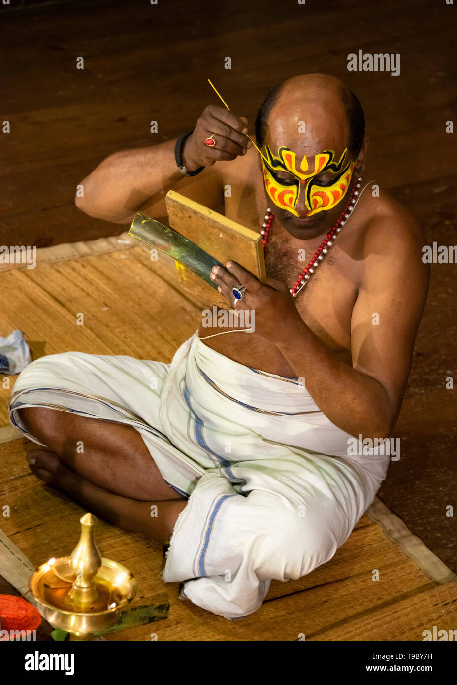Vue aérienne verticale d'un artiste de Kathakali appliquer son maquillage distinctif au Kerala, en Inde. Banque D'Images