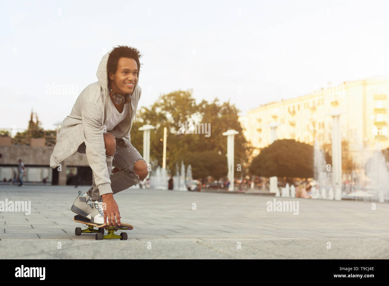 African American Teen Guy Skateboarding sur soirée d'été Banque D'Images