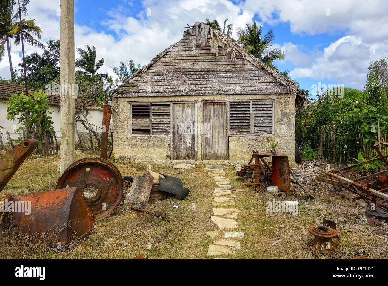 Vintage Vieille maison de ferme et d'extérieur de bâtiment avec cour avant pièces de machines rouillées dans la campagne cubaine traditionnelle Village Rural Banque D'Images