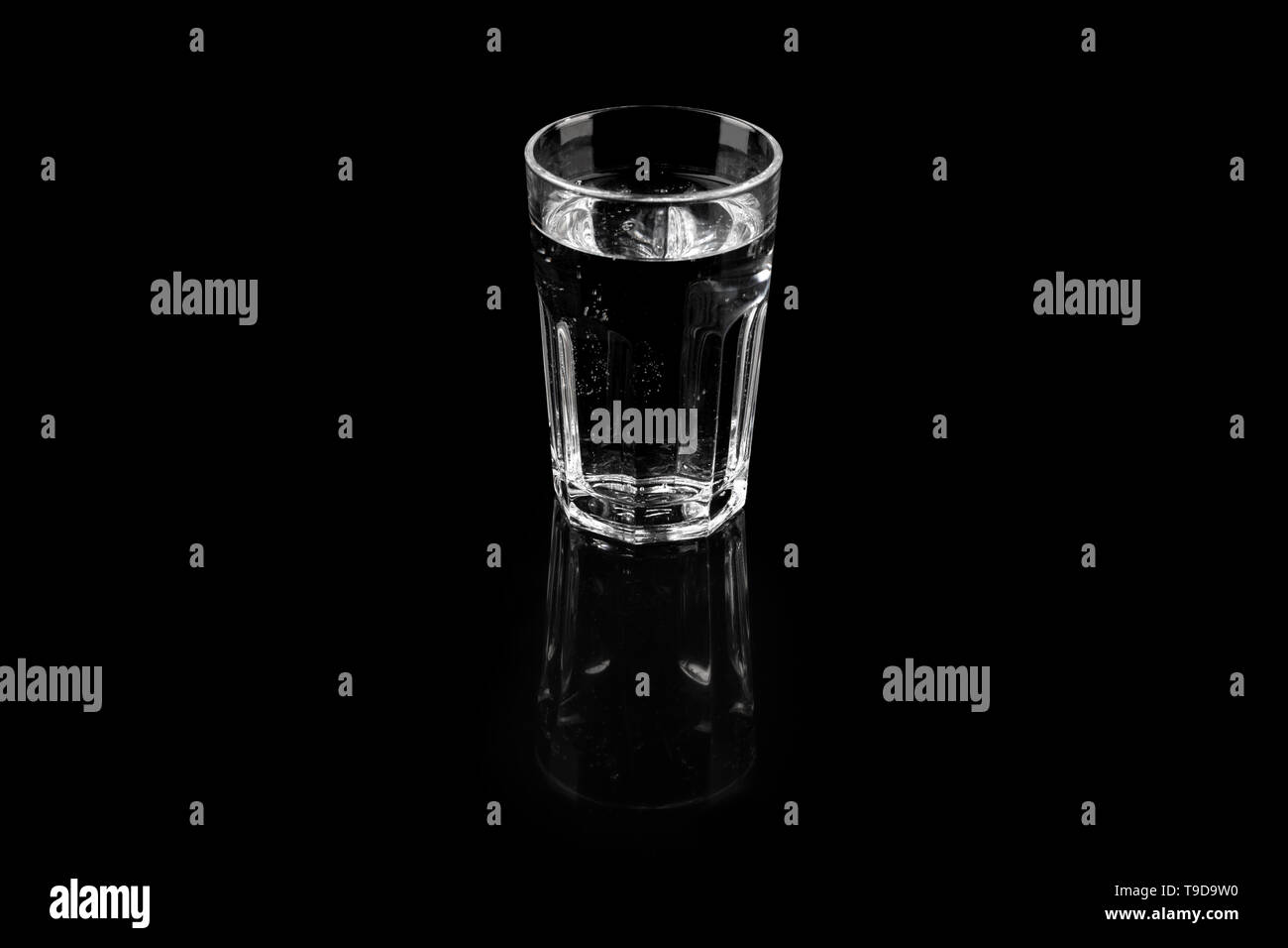 Verre d'eau minérale pure et rafraîchissante de l'eau fraîche sur fond noir Banque D'Images
