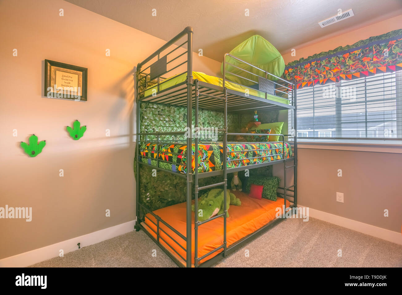 Cette chambre confortable à l'intérieur avec un lit superposé triple  colorée pour les enfants. La lumière du soleil d'eau à l'intérieur de la  chambre à travers la fenêtre de verre avec des