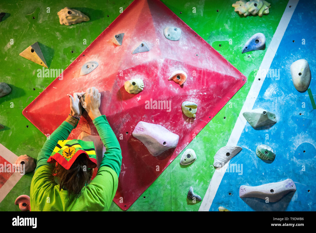 Un female rock climber pratiquant sur le mur d'escalade. Banque D'Images