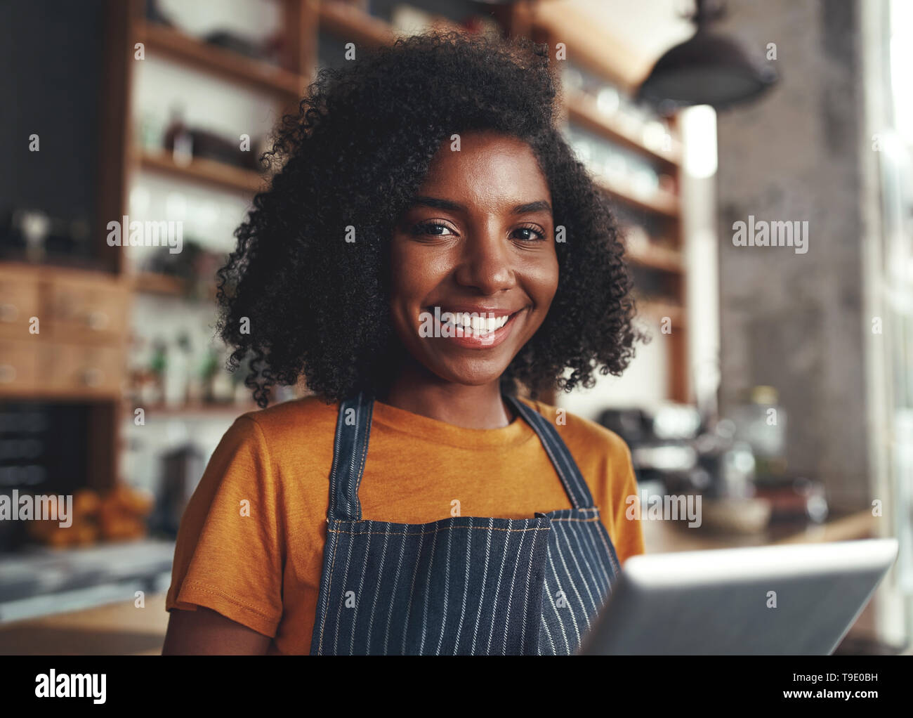 Happy young woman standing dans son café Banque D'Images