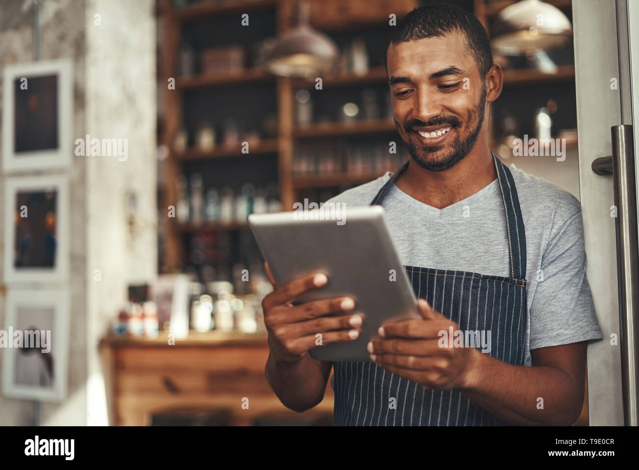 Café barista réussie owner looking at digital tablet Banque D'Images